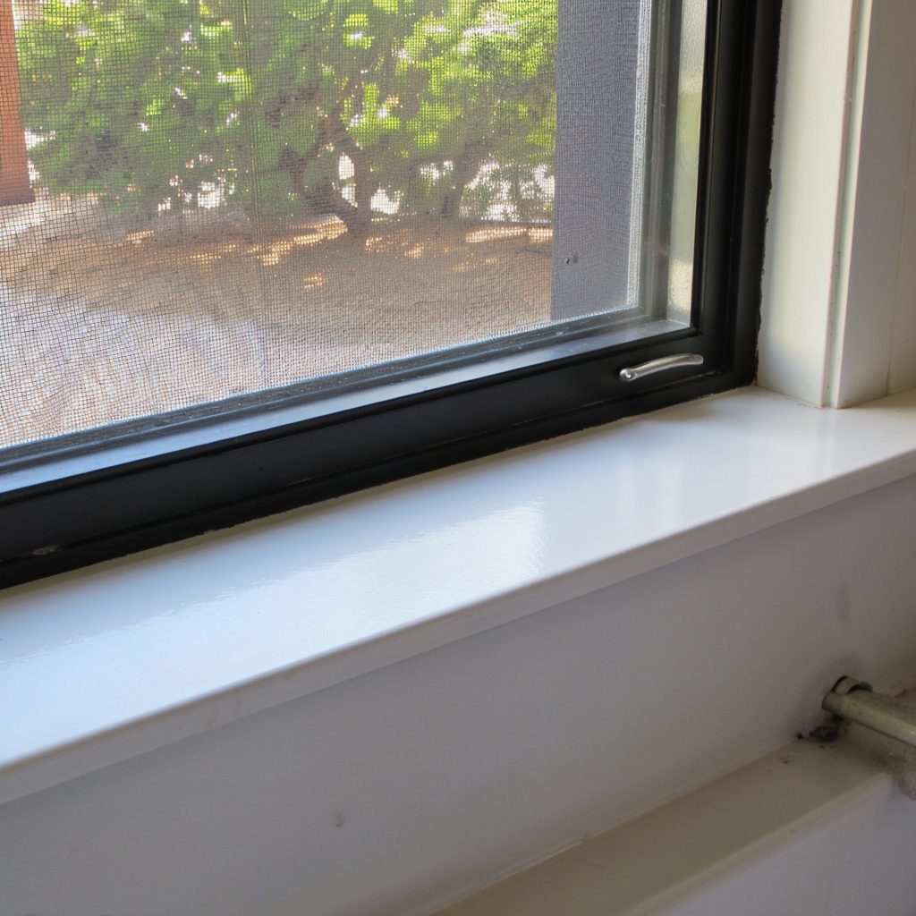 Close-up of a window frame sealed with silicone sealant, highlighting proper application for weatherproofing and durability.