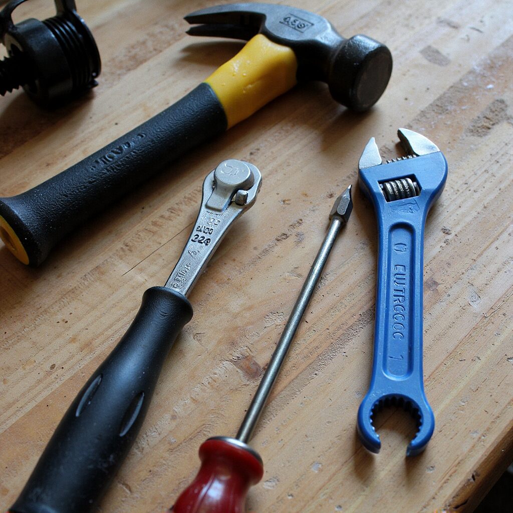 A set of home repair tools neatly arranged on a wooden workbench.